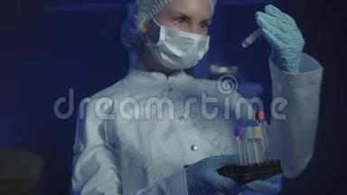 年轻女医生戴着医用面具看镜头的肖像。 医生手里拿着锥子